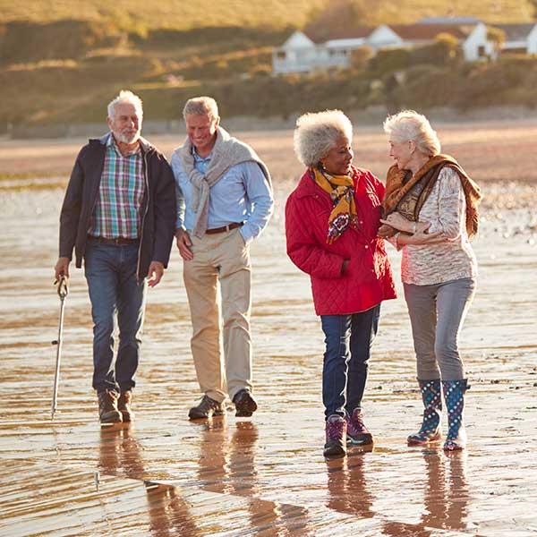 Two couples walking on the beach